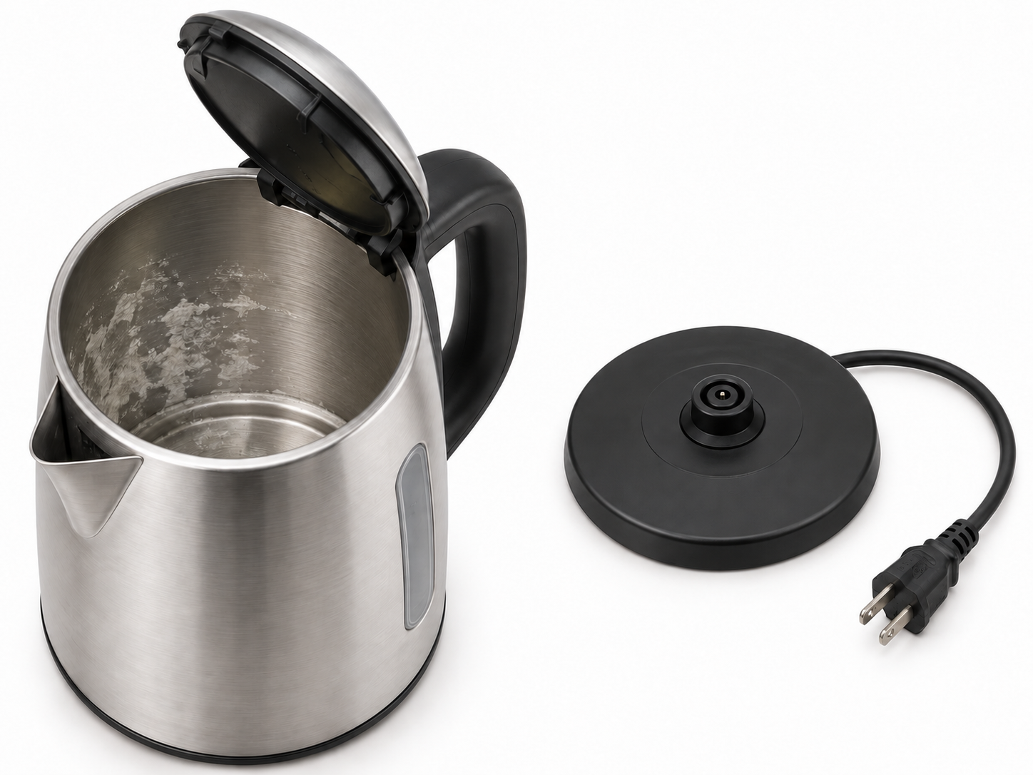 Open, cooled kettle with light mineral scale beside a separate dry electrical base and visibly unplugged cord; no cleaning tool inside.